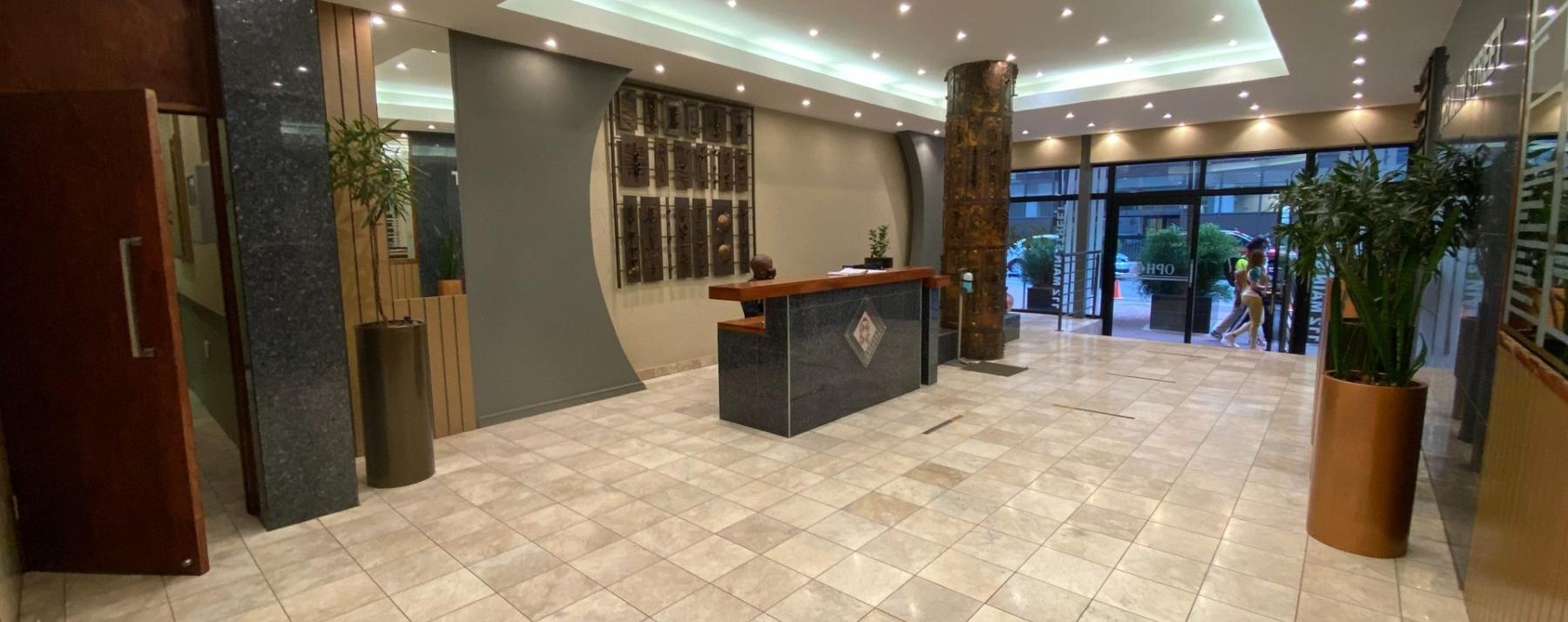 Modern commercial office reception area with tiled flooring and reception desk 